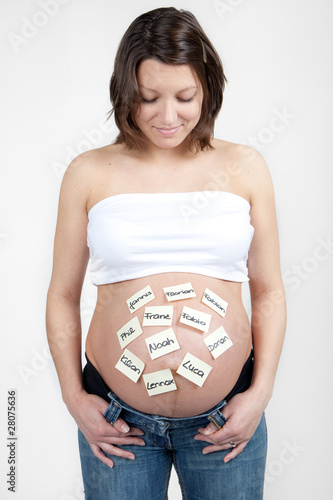 Happy woman is looking on her baby tummy full with names photo
