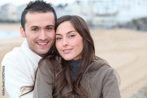 Young couple spending a week-end at the beach in winter
