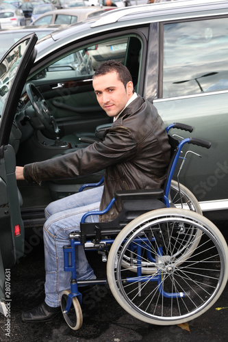 Young man in wheelchair getting in his car © goodluz