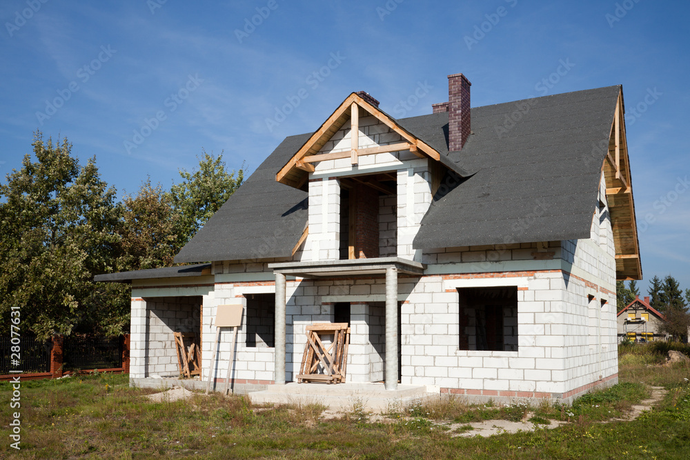 Unfinished house of brick against blue sky