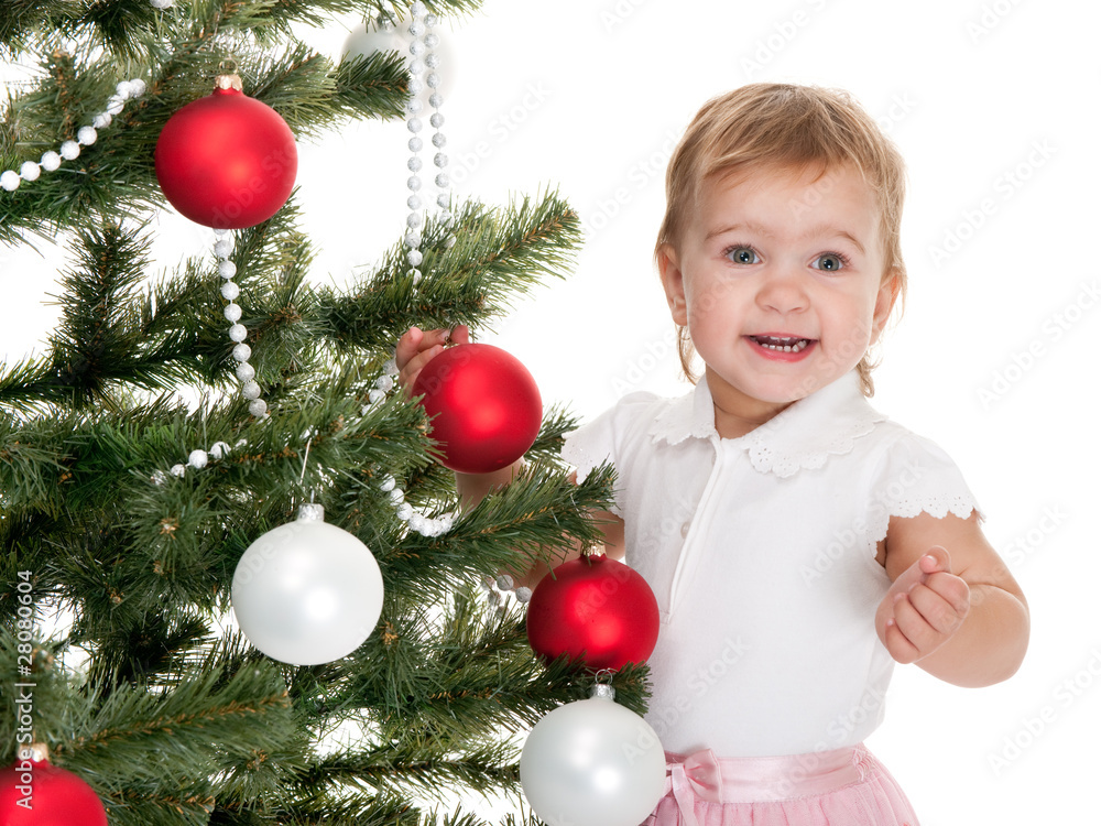 Happy little girl decorating a christmas tree Happy little girl decorating a christmas tree