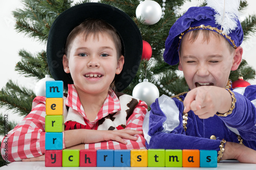 Two boys greet with merry christmas at the christmas masket ball photo