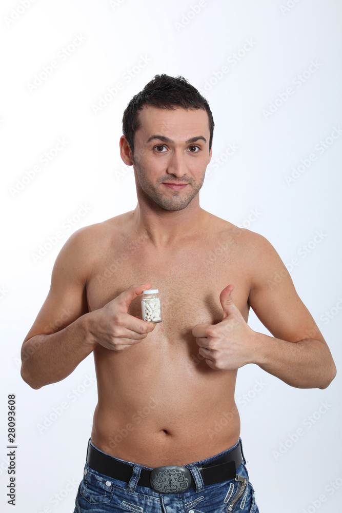 Fototapeta premium Smiling man holding bottle of pills