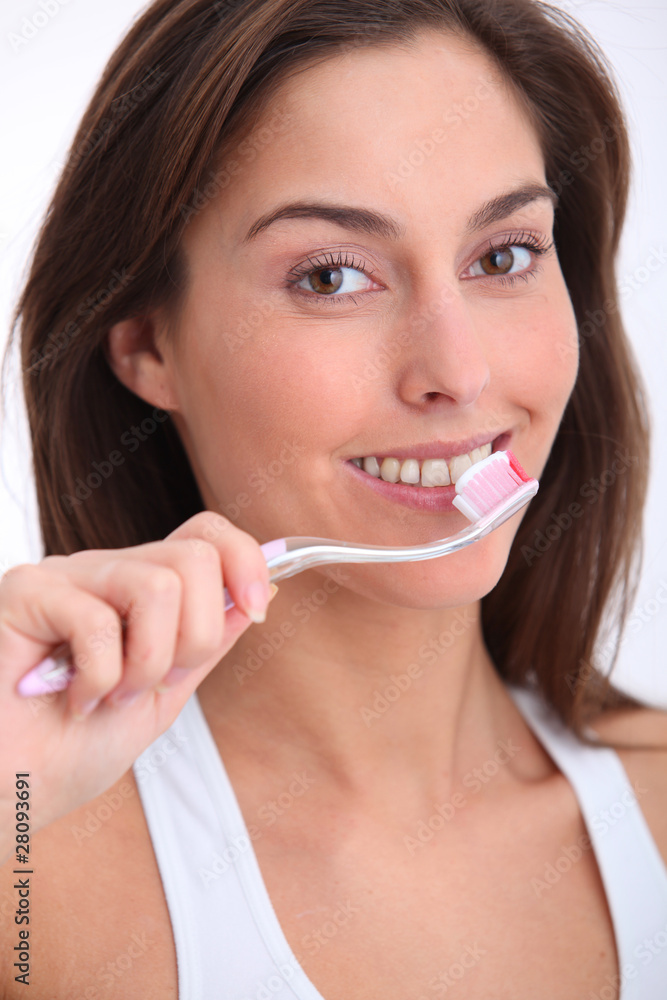 Closeup of beautiful woman brushing her teeth