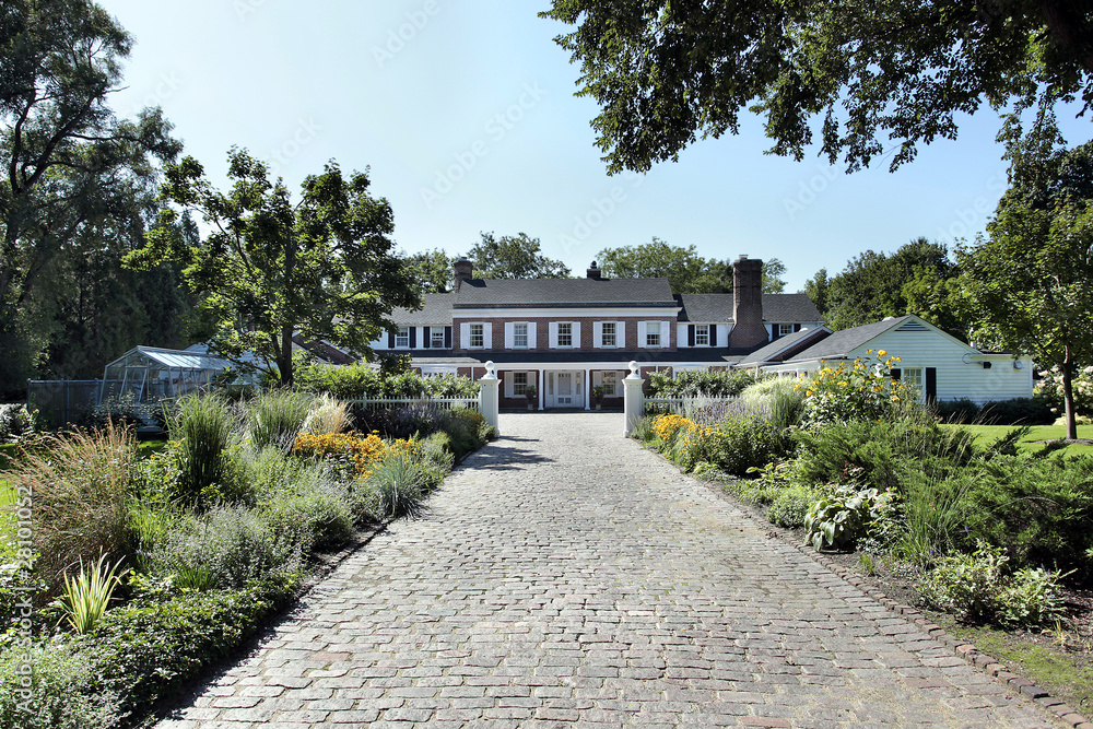 Fototapeta premium Luxury home with long brick driveway