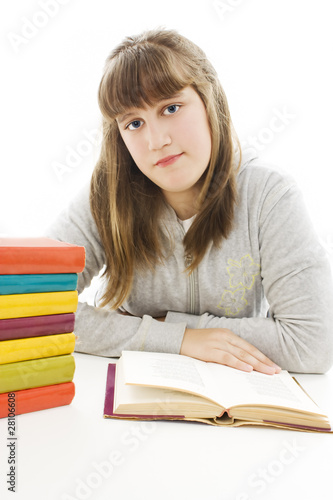 Young girl sitting at the desk and reading book.