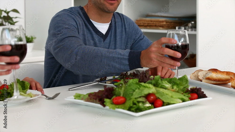 Portrait of a couple having lunch with red wine in the kitchen Portrait of a couple having lunch with red wine in the kitchen