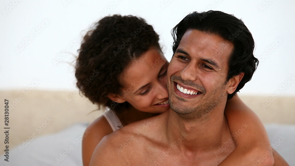 Lovely couple hugging sitting on the bed at waking Lovely couple hugging sitting on the bed at waking