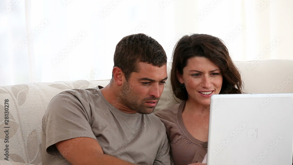 Surprised couple surfing on the web together at home Surprised couple surfing on the web together at home
