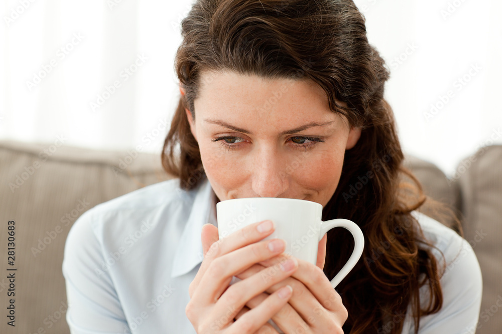 Pretty businesswoman drinking coffee on the sofa Pretty businesswoman drinking coffee on the sofa