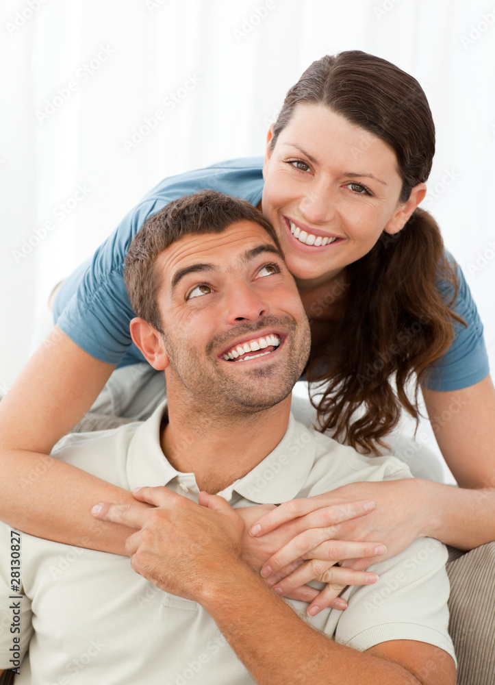 Portrait of a pretty woman hugging her husband on the sofa Portrait of a pretty woman hugging her husband on the sofa