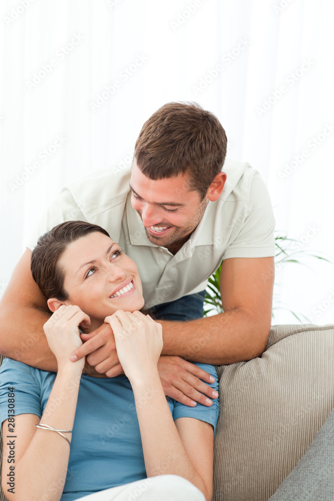 Affectionate man talking with his girlfriend sitting on the sofa Affectionate man talking with his girlfriend sitting on the sofa