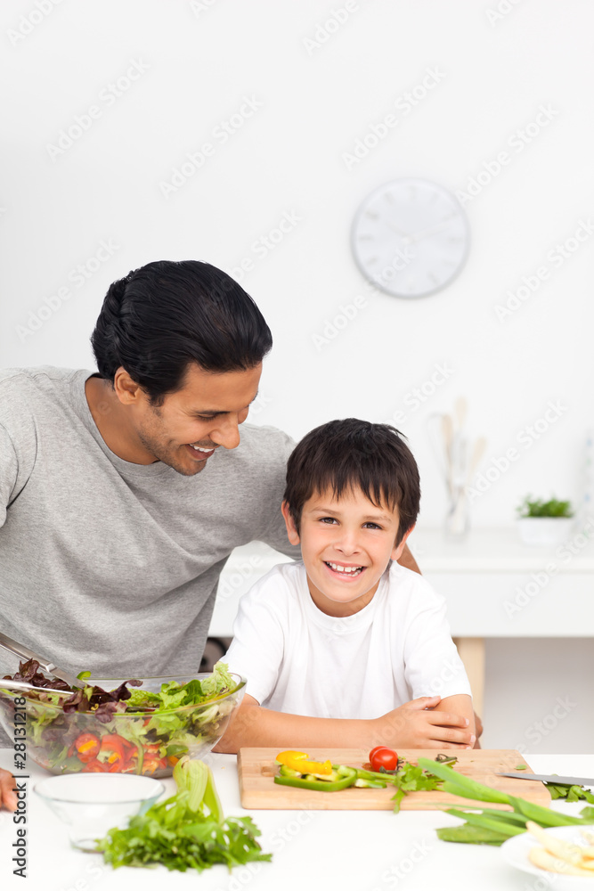 Happy father and son preparing vegetables together Happy father and son preparing vegetables together