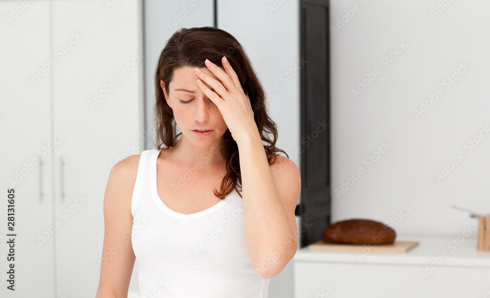Exhausted woman having a headache in her bathroom Exhausted woman having a headache in her bathroom