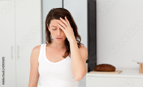 Exhausted woman having a headache in her bathroom