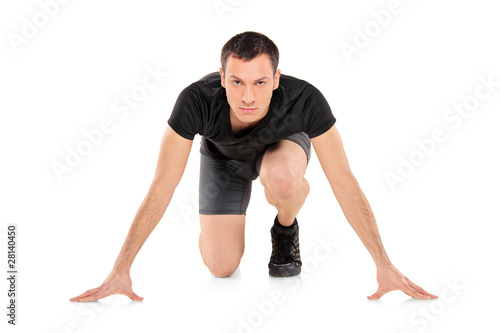 Full length portrait of an athlete ready to run, looking towards