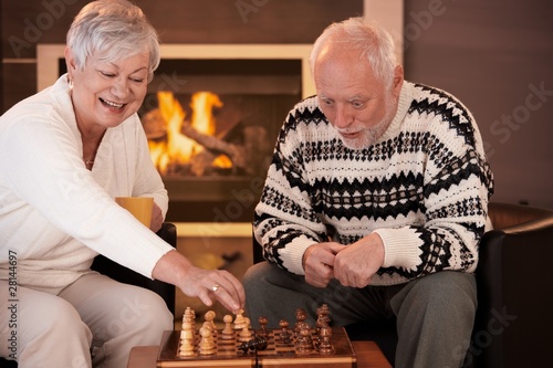 Senior couple having fun with chess photo