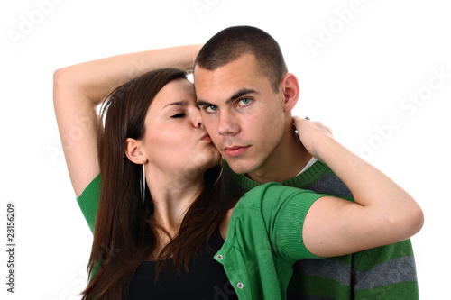Young girl kisses and hugs her boyfriend isolated on white