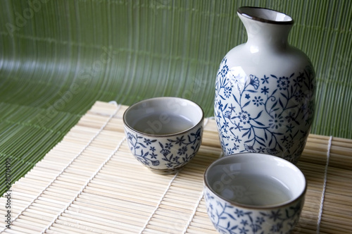Sake set on bamboo pad and green background