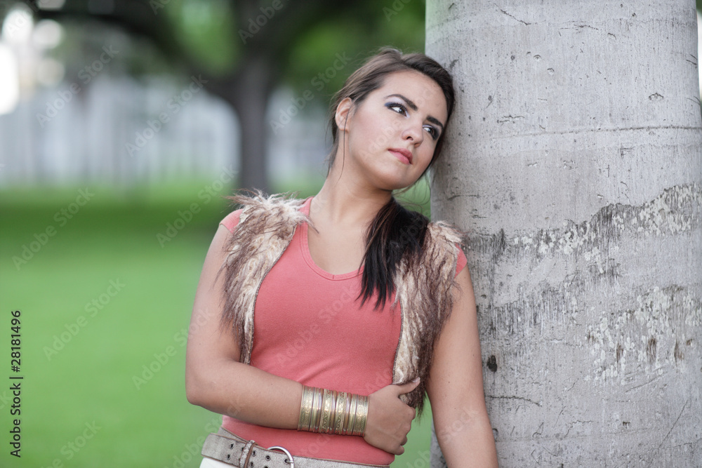 Image of a woman leaning on a tree