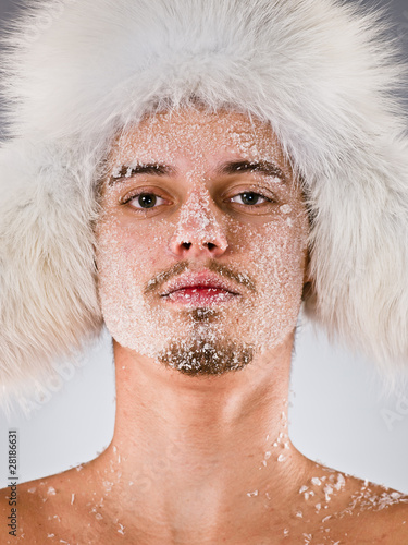 Young man in fur cap with face covered with hoarfrost