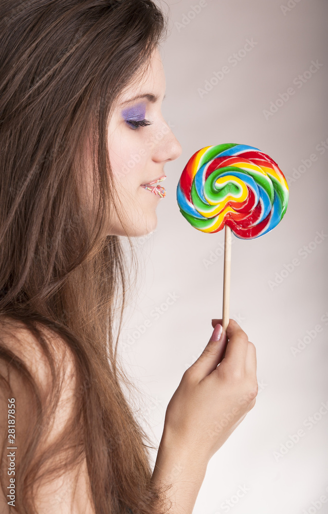 closeup of a beautiful girl licking a colorful lollipop