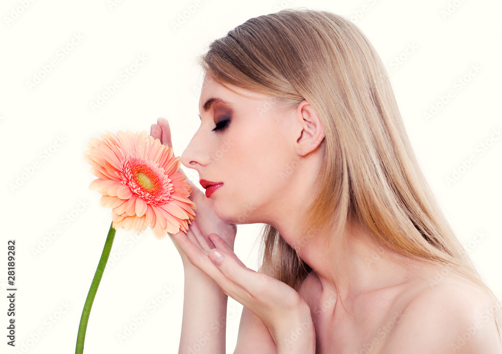Woman on white background smelling pink flower
