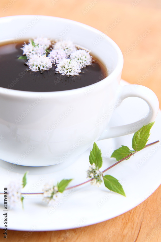 Cup of tea with mint flowers floating in it Cup of tea with mint flowers floating in it