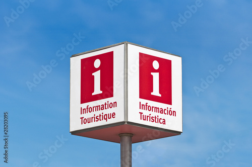 Red lettered tourist information sign over a blue sky