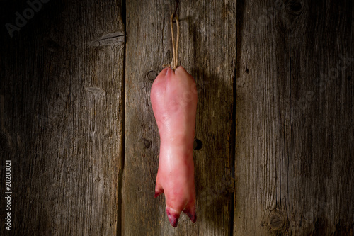 pig trotter on wood- zampone appeso su legno photo