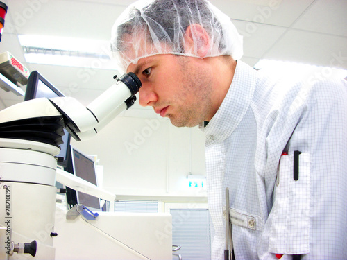 Tableau sur toile The men looks in stereomicroscope eyepieces
