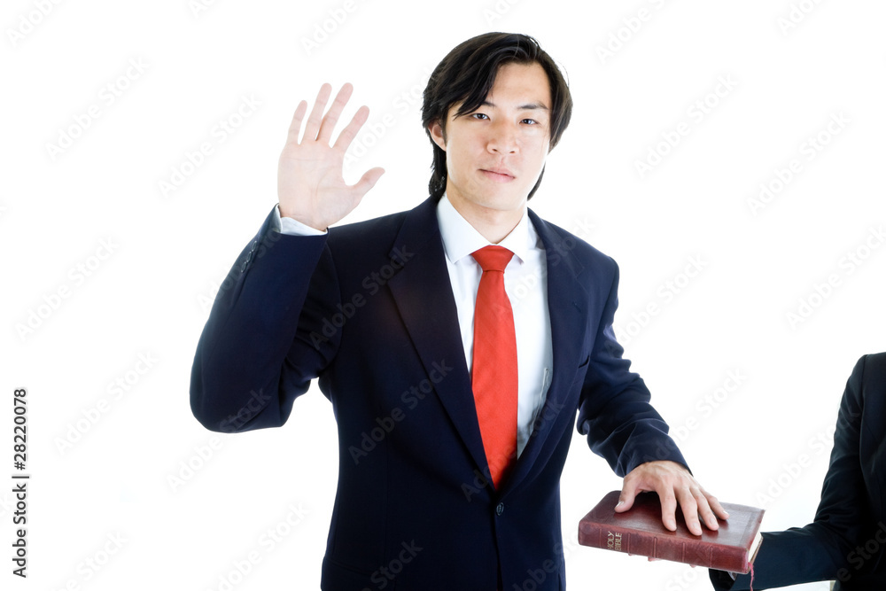 Asian Man Raise Hand Swearing on Bible Isolated White Background Asian Man Raise Hand Swearing on Bible Isolated White Background