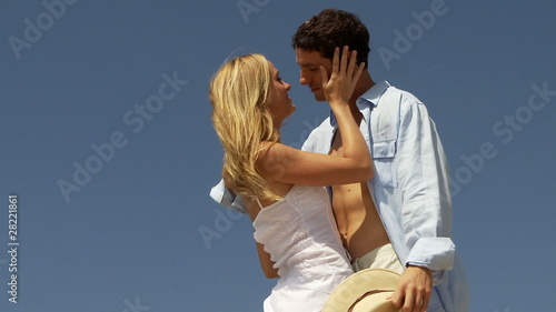 Close up of young couple coming together for a kiss at the beach