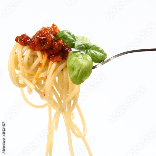 Spaghetti bolognese with basil leaves on a fork