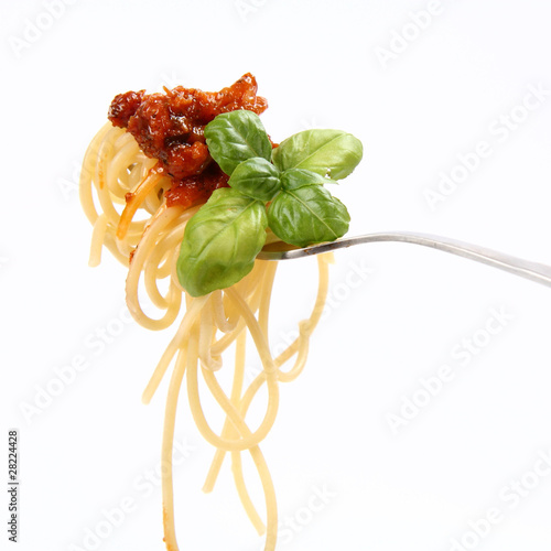 Spaghetti bolognese with basil leaves on a fork