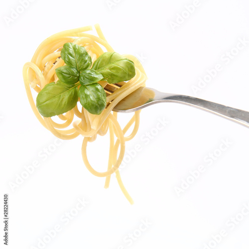 Spaghetti with basil leaves on a fork