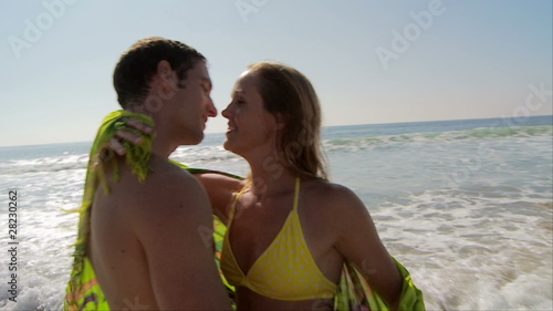 Young couple kissing at ocean’s edge