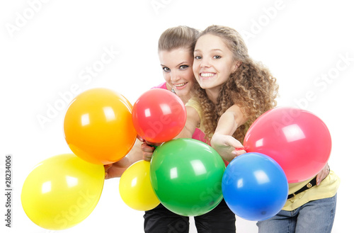 two young happy girls with balloons over white