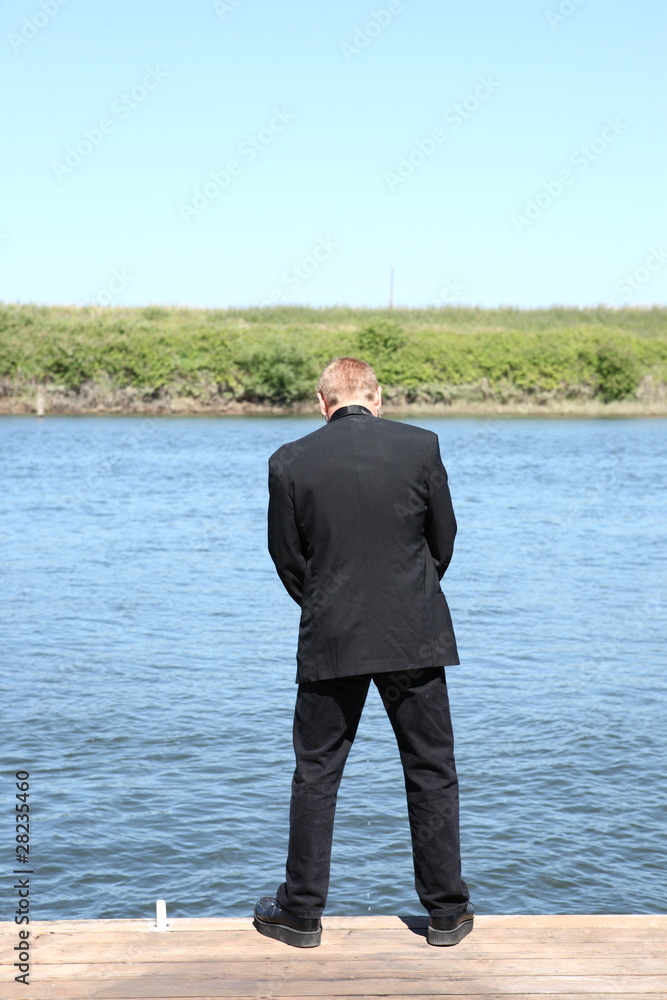 Man in suit peeing in the river