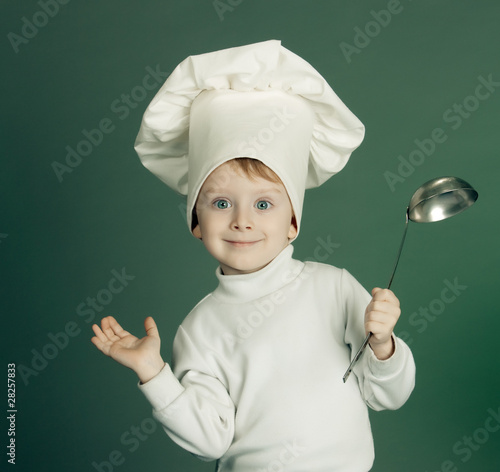 The little boy in a suit of the cook has control over a ladle