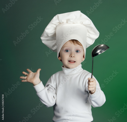 The little boy in a suit of the cook has control over a ladle