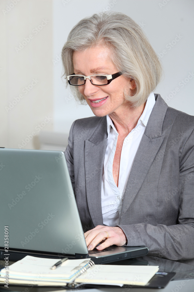 Senior businesswoman with eyeglasses working in the office Senior businesswoman with eyeglasses working in the office