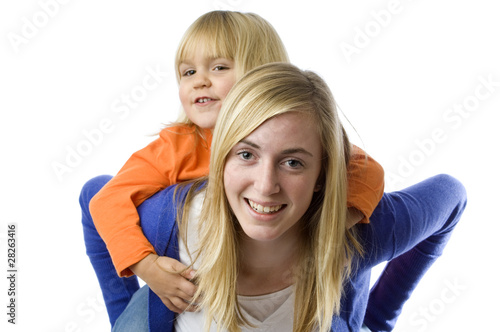Teenage girl piggybacks a todler.