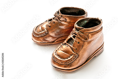 Babyshoes in bronze, on white background photo