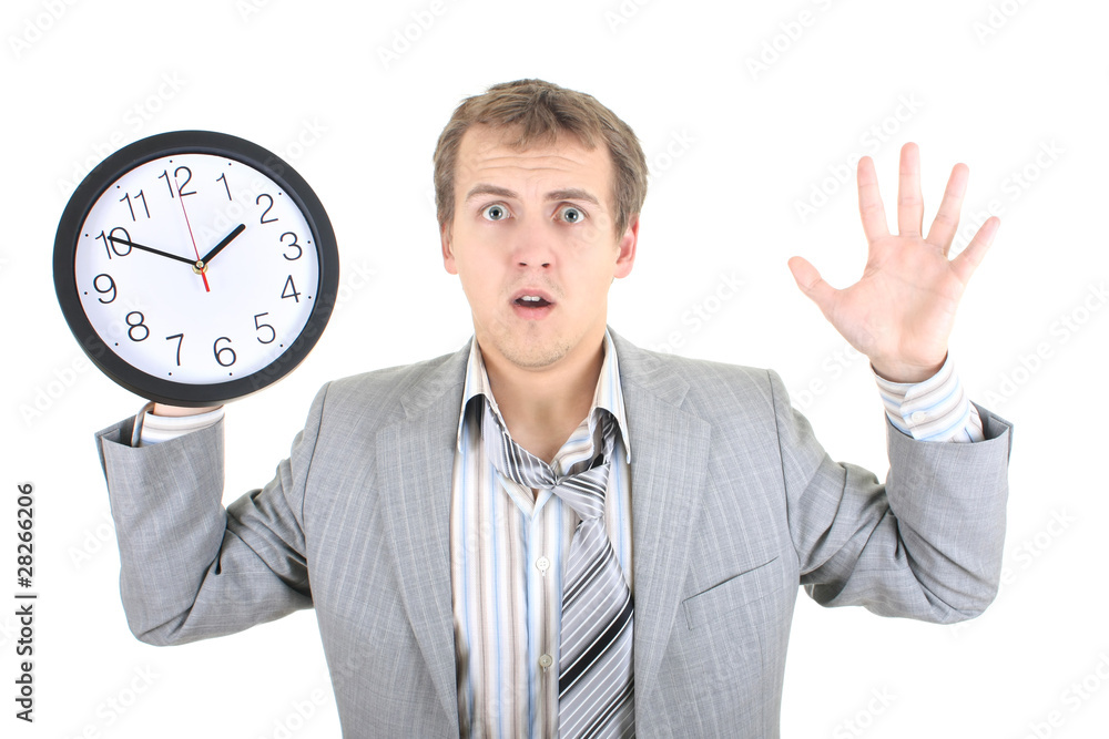 Amazed businessman in grey suit holding a clock Amazed businessman in grey suit holding a clock