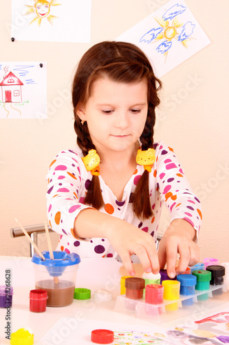 young and cute little girl painting a picture