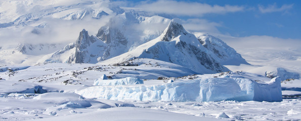 Poster Antarctica Besneeuwde bergtoppen onder helder licht  © Goinyk