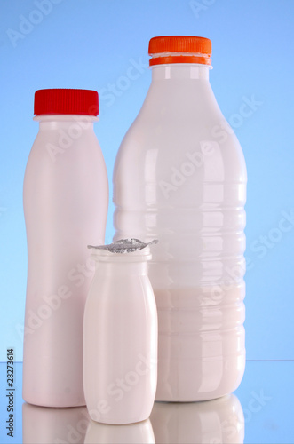 Bottles of milk on blue background