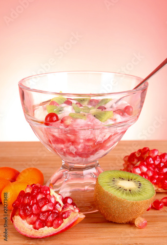 some coctail with fruits in glass with spoon on red background photo