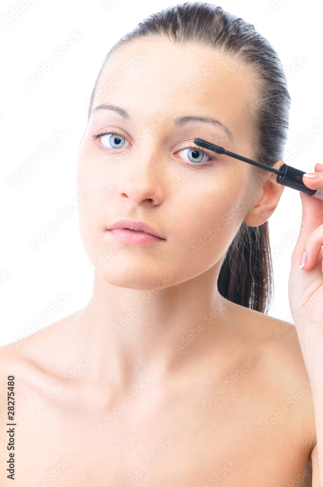 young attractive sensual woman is applying cosmetics on her face